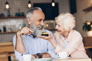 an older couple enjoying coffee and dessert at a cafe