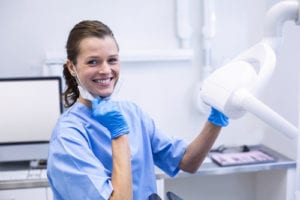 portrait of a dental hygienist ready to perform a dental cleaning