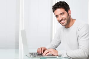 portrait of smiling man working on laptop