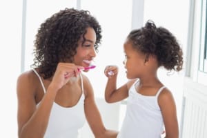 mother and daughter brushing their teeth in the bathroom