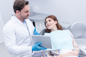 dentist showing patient records on tablet