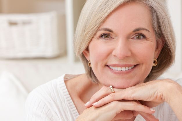 senior woman smiling after receiving dental implants