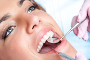 close up of woman a dentist office for restorative dentistry with dental mirror and pick in her mouth