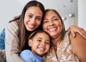 Love, family and portrait of multigenerational women on a sofa, relax, happy and bonding in a living room. Portrait, mother, girl and grandma smile, hug and relaxing on a couch enjoying quality time.