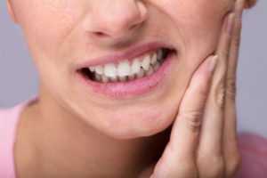close up of woman dealing with tooth sensitivity
