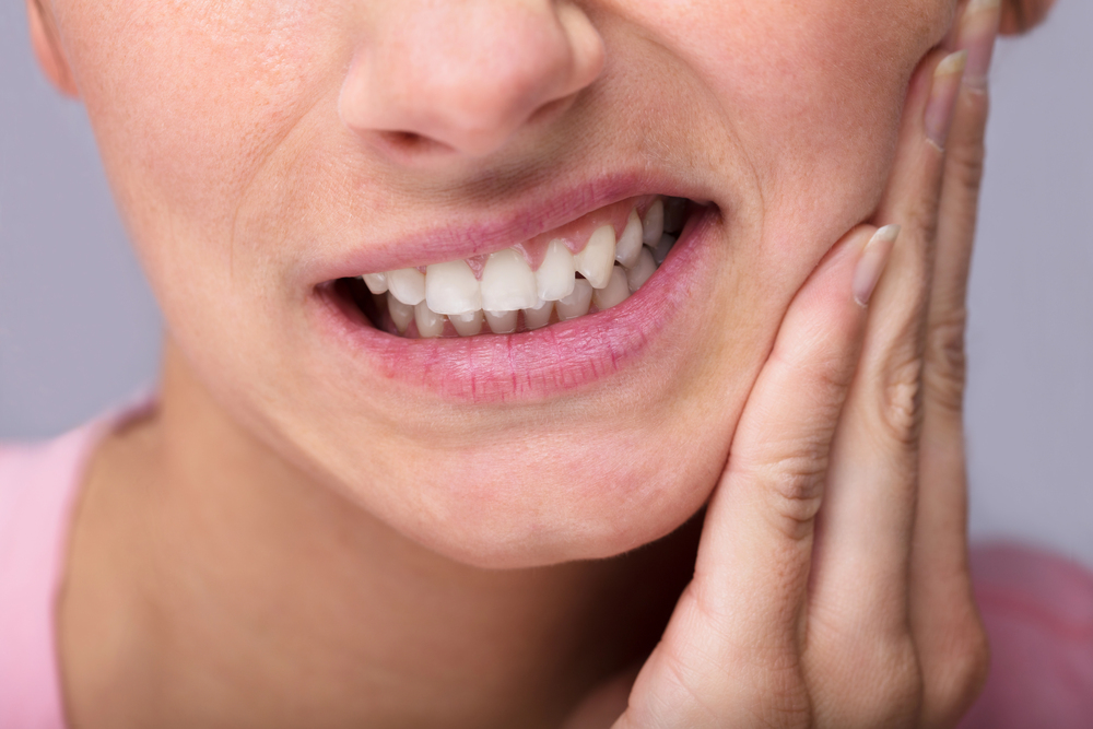 close up of woman dealing with tooth sensitivity